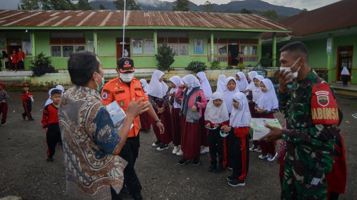 Kawasan rawan bencana Gunung Marapi di Agam Petugas BPBD Agam dan anggota TNI membagikan masker untuk antisipasi abu vulkanik kepada pelajar SDN 12 Batang Silasiah, Nagari Bukik Batabuah, Agam, Sumatera Barat, Kamis (11/1/2024). BPBD Agam, TNI dan tim gabungan mendirikan posko dan melakukan sosialisasi serta edukasi sebagai langkah kesiapsiagaan bencana di kawasan rawan bencana Gunung Marapi yang jaraknya sekitar 4,7 kilometer dari pusat kawah itu. ANTARA FOTO/Iggoy el Fitra/nz