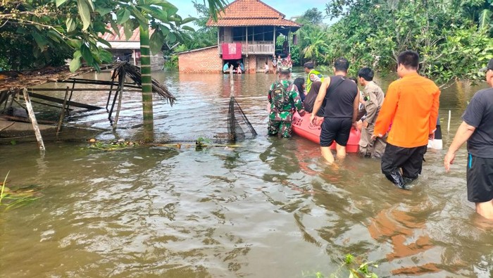 Petugas mengevakuasi warga yang rumahnya terendam banjir