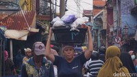 Pedagang sedang memanggul ikan yang akan dijual kembali di Pasar Ikan Pabean.
