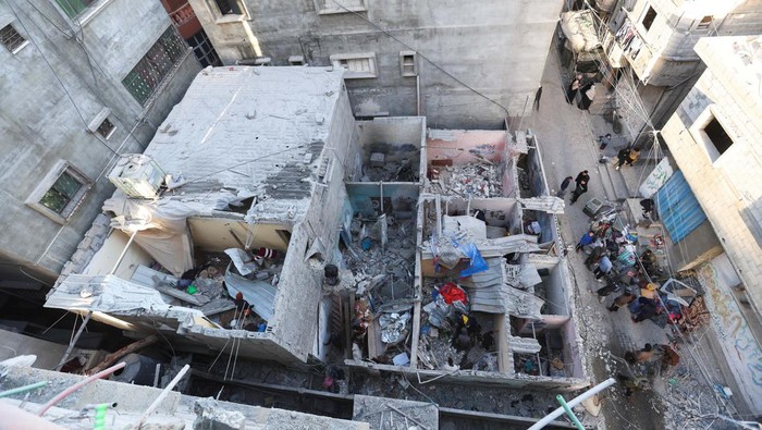 Debris lies in a damaged room, as a Palestinian man is reflected in a mirror, at the site of an Israeli strike, amid the ongoing conflict between Israel and the Palestinian Islamist group Hamas, in Rafah in the southern Gaza Strip January 10, 2024. REUTERS/Ibraheem Abu Mustafa