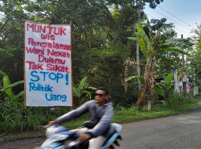 Spanduk bertulisan Muntuk Wis Pengalaman, Wani Nekat Duitmu Tak Sikat, Stop Politik Uang! di sekitar Kantor Kalurahan Muntuk, Kapanewon Dlingo, Kabupaten Bantul. Diunggah Kamis (11/1/2024).