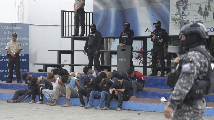 Police present to the press the arrested men who the police identify as the previous day's attackers on the TC Television station, at police headquarters in Guayaquil, Ecuador, Wednesday, Jan. 10, 2024. No one was killed in Tuesday’s attack and authorities say the 13 attackers were arrested and would be charged with terrorism. (AP Photo/Cesar Munoz)