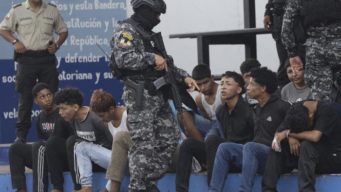 Police present to the press the arrested men who the police identify as the previous day's attackers on the TC Television station, at police headquarters in Guayaquil, Ecuador, Wednesday, Jan. 10, 2024. No one was killed in Tuesday’s attack and authorities say the 13 attackers were arrested and would be charged with terrorism. (AP Photo/Cesar Munoz)