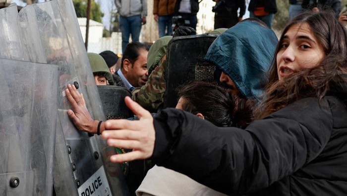 Warga Palestina Tolak Kedatangan Antony Blinken ke Ramallah Riot police officers stand guard while Palestinians protest against U.S. Secretary of State Antony Blinken's visit and his meeting with Palestinian President Mahmoud Abbas, amid the ongoing conflict between Israel and the Palestinian Islamist group Hamas, in Ramallah in the Israeli-occupied West Bank, January 10, 2024. REUTERS/Ammar Awad
