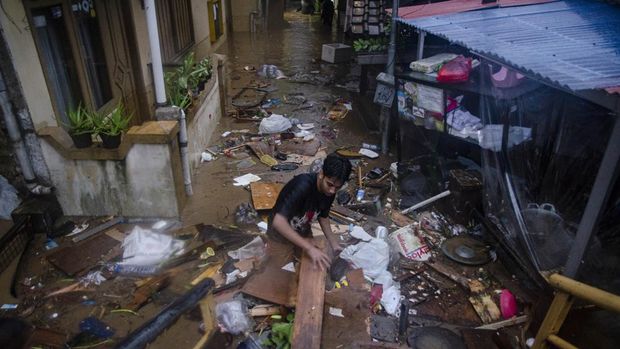 Warga menyingkirkan puing dan sampah yang terbawa air di permukiman padat Braga, Bandung, Jawa Barat, Kamis (11/1/2024). Sedikitnya 100 rumah warga di kawasan tersebut terendam banjir dan rusak akibat meluapnya aliran Sungai Cikapundung saat intensitas curah hujan tinggi. ANTARA FOTO/Novrian Arbi/tom.