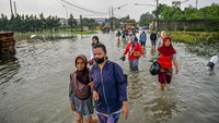 Buruh pabrik melintasi banjir di Kawasan Industri Sapan, Kabupaten Bandung, Jawa Barat. 