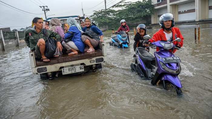 Banjir di Kawasan Industri Sapan Buruh pabrik naik di atas pikap untuk melintasi banjir di Kawasan Industri Sapan, Kabupaten Bandung, Jawa Barat, Jumat (12/1/2024). Hujan besar yang mengguyur Bandung Raya pada Kamis (12/1/2024) membuat akses Kawasan Industri Sapan terendam air setinggi 30 hingga 60 sentimeter sehingga berdampak pada aktivitas buruh pabrik di kawasan tersebut. ANTARA FOTO/Raisan Al Farisi/rwa.