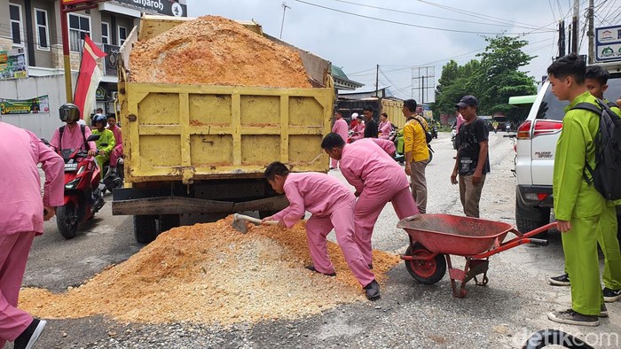 Foto: Pelajar saat memperbaiki jalan rusak (Raja Adil Siregar)