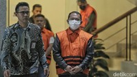 Dia tampak mengenakan baju tahanan KPK. Tangannya pun telah diborgol.