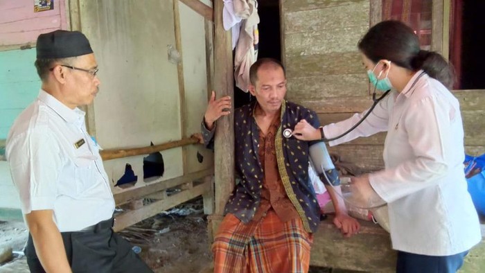 Petugas memeriksa kesehatan satu keluarga yang lumpuh di Lebak