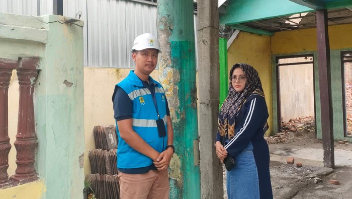 Petugas PLN melakukan survei rumah warga yang ingin pindah tiang listrik di Sidoarjo.
