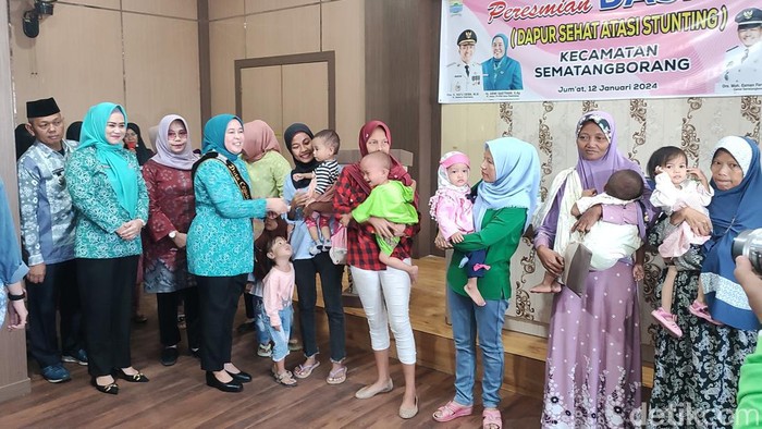 PJ Ketua TP PKK kota Palembang, Hj. Dewi Sastrani saat membagikan bantuan kepada orang tua balita yang terkena stunting.