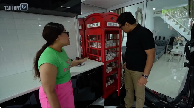 Sebuah lemari piring dan gelas mencuri perhatian. Bentuknya menyerupai bilik telepon umum di Inggris dengan warna merahnya yang mencolok.(Foto: YouTube/Taulany TV)