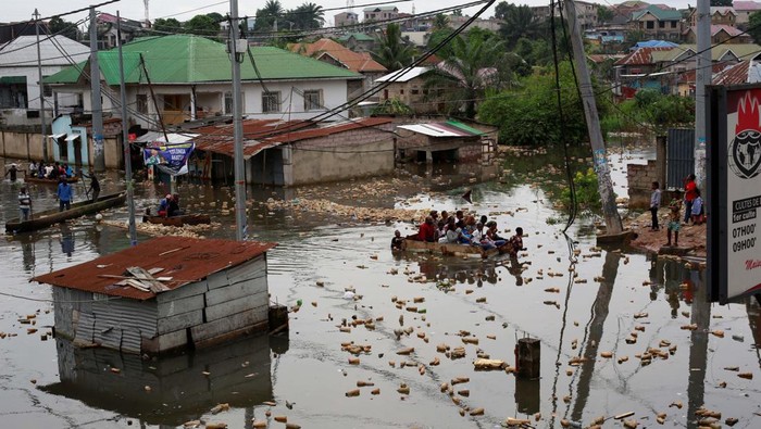 People use a makeshift boat to move after the Congo River rises to its highest level, causing flooding in Kinshasa, Democratic Republic of Congo January 10, 2024.REUTERS/Justin Makangara