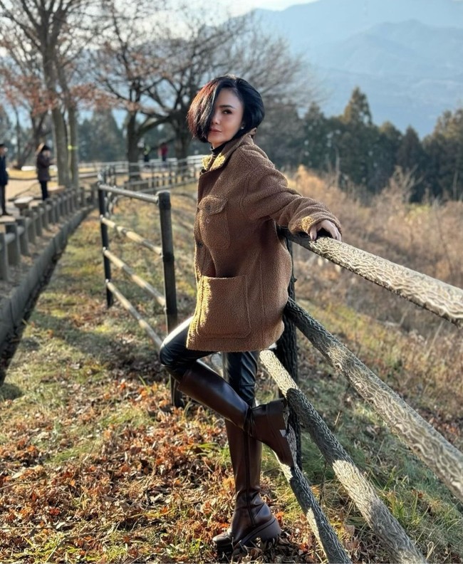 Ini gaya liburan Yuni Shara yang menawan saat mengenakan baju hangat berwarna coklat yang dipadupadankan dengan legging latex hitam dan sepatu boots yang senada. Foto: Dok. Instagram yunishara36