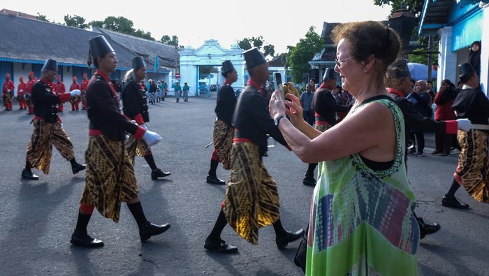 Wisatawan asing mengabadikan parade prajurit Keraton Kasunanan Surakarta Hadiningrat di halaman keraton setempat, Solo, Jawa Tengah, Sabtu (13/1/2024). Dinas Kebudayaan dan Pariwisata Kota Solo menargetkan jumlah kunjungan wisatawan nusantara sebanyak 1.498.850 orang dan wisatawan mancanegara sebanyak 5.192 orang pada tahun 2024.ANTARAFOTO/Maulana Surya/nym.