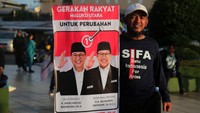Relawan AMIN menunjukkan spanduk Anies-Muhaimin sebelum mengikuti jalan sehat di Landmark Ternate, Kota Ternate, Maluku Utara, Minggu (14/1/2024).