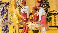 Momen Sultan Hassanal Bolkiah menuangkan minyak wangi ke telapak tangan Pangeran Abdul Mateen sebagai salah satu prosesi jelang pernikahan. Momen sakral ini terjadi di Istana Nurul Iman. (Foto: AFP/RUDOLF PORTILLO)