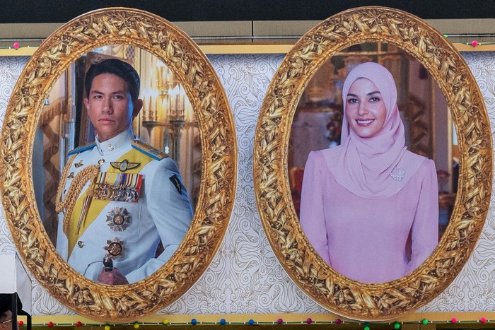 BRUNEI-ROYAL-WEDDING The portraits of groom Prince Abdul Mateen (L) and his bride Yanh Mulia Anisha Rosnah (R) are seen on a billboard ahead of their wedding procession in Bandar Seri Begawan on January 13, 2024. (Photo by Mohd RASFAN / AFP)