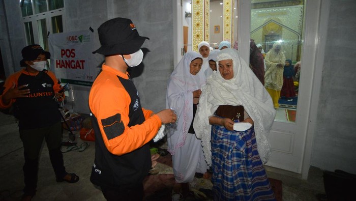 Relawan membagikan masker kepada jamaah masjid akibat hujan abu vulkanik, di Pokso Bencana Gunung Marapi, Batang Silasiah, Nagari Bukik Batabuah, Agam, Sumatera Barat, Sabtu (13/1/2024). Pos Pengamatan Gunung Api Marapi di Bukittinggi mencatat gunung tersebut kembali erupsi pada Sabtu (13/1/2024) pukul 19.33 WIB yang menyebabkan hujan abu di sekitar kaki gunung yang kini berstatus siaga level III itu. ANTARA FOTO/Iggoy el Fitra/nym.