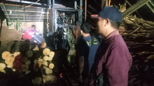 Petugas Damkar Klungkung melaksanakan pemadaman kebakaran usaha potong kayu, Minggu (14/1/2024).