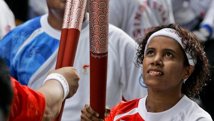 Athens 2004 Olympic weightlifting silver-medalist Lisa Rumbewas receives a relay during the Beijing Olympic torch relay at the main stadium in Jakarta, Indonesia, Tuesday, April 22, 2008. (AP Photo/Dita Alangkara)