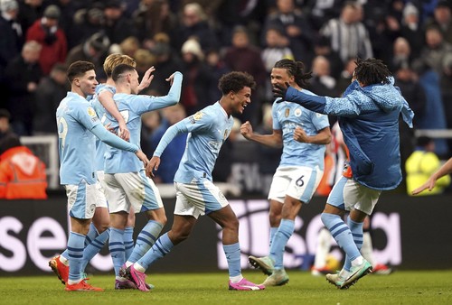 Manchester Citys Oscar Bobb celebrates scoring his sides third goal of the game, during the English Premier League soccer match between Newcastle United and Manchester City, at St. James Park, in Newcastle upon Tyne, England,  Saturday, Jan. 13, 2024. (Owen Humphreys/PA via AP)