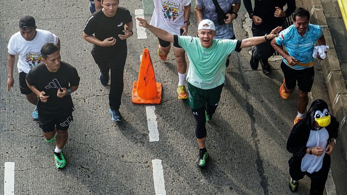 Momen Ganjar Ikut Lari Pagi Penguin SeliweRUN Calon presiden nomor urut 3 Ganjar Pranowo (ketiga kiri) berselebrasi usai melewati garis finish saat mengikuti kegiatan Penguin Seliwerun di Senayan Park, Jakarta, Minggu (14/1/2024). Kegiatan tersebut dilaksanakan untuk mengajak masyarakat menjalani hidup sehat dan sebagai simbol dari program Gerak Cepat (Gercep) yang diusung Pasangan Capres Cawapres nomor urut 3. ANTARA FOTO/Rifqi Raihan Firdaus/foc.