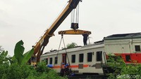 Petugas KAI sedang memasang rantai untuk mengangkut gerbong yang anjlok dengan menggunakan crane.