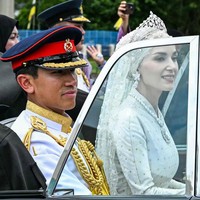 Setelah menjalani ritual upacara, keduanya keluar dari gedung dan menumpang mobil kerajaan untuk menyapa warga. Foto: AFP/IQBAL DATO HJ SELAMAT