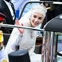 Pangeran Abdul Mateen dan Anisha Rosnah tampak melambaikan tangan dan tersenyum. Foto: AFP/IQBAL DATO HJ SELAMAT