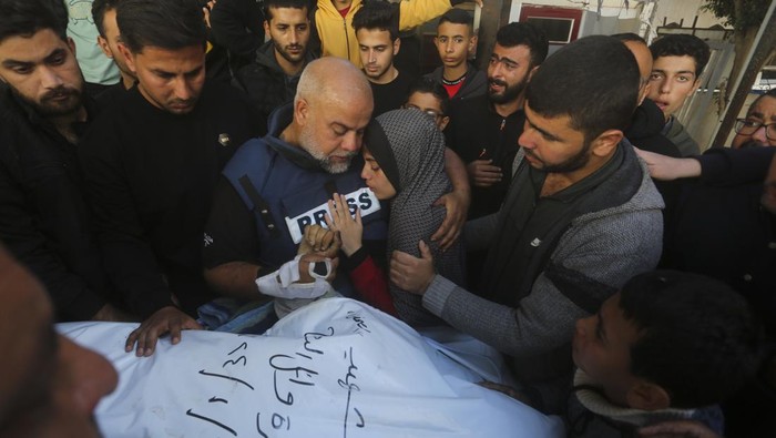 Al Jazeera journalist Wael Dahdouh holds the hand of his son Hamza, who also worked for Al Jazeera and who was killed in an Israeli airstrike in Rafah, Gaza Strip, Sunday, Jan. 7, 2024. Dahdouh lost his wife, two other children, and a grandson earlier in the war and was nearly killed himself. (AP Photo/Hatem Ali)