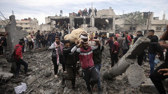 Palestinians evacuate a wounded woman following Israeli airstrikes in Khan Younis refugee camp, southern Gaza Strip, Thursday, Dec. 7, 2023. (AP Photo/Mohammed Dahman)