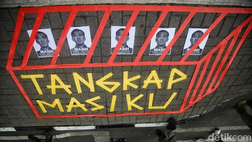 Aktivis anti korupsi yang tergabung dalam Indonesia Corruption Watch (ICW) melakukan aksi teatrikal untuk memperingati 4 tahun buron Harun Masiku, di depan Gedung KPK, Jakarta, Senin (15/1/2024). 4 orang bertopeng pimpinan KPK dan satu orang bertopeng Harun Masiku meniup lilin pada kue tart sebagai simbol hilangnya Harun Masiku. Aksi berlangsung tertib.