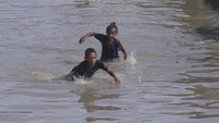 Beberapa anak-anak memanfaatkan banjir untuk bermain.