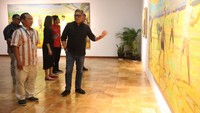 Hasto pun memulai menikmati pameran lukisan karya Budi Ubrux berjudul Maju Tak Gentar. Di mana, lukisan itu berisi gambaran para pemuda yang mengangangkat pacul.