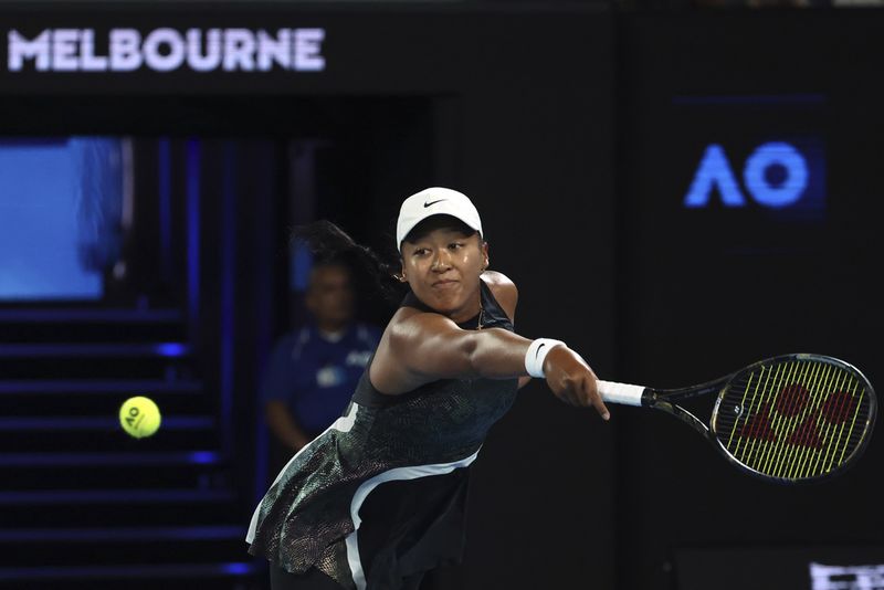 Naomi Osaka of Japan plays a backhand return to Caroline Garcia of France during their first round match at the Australian Open tennis championships at Melbourne Park, Melbourne, Australia, Monday, Jan. 15, 2024. (AP Photo/Asanka Brendon Ratnayake)