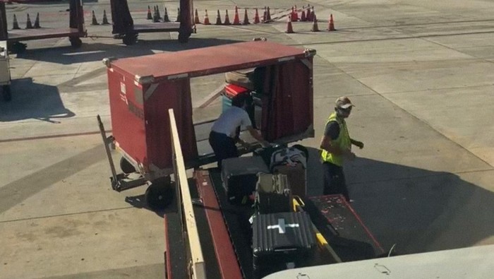 Pilot bantu bongkar muat bagasi pesawat