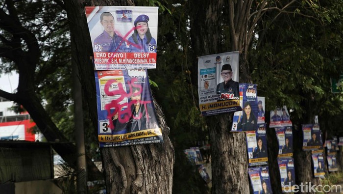 Potret Poster Caleg Dicap Tersangka Penusukan Pohon Sejumlah poster caleg yang di tempel di pohon sepanjang jalan Yos Sudarso, Jakarta Utara, Senin (15/1/2024). Poster-poster caleg yang terpaku di pohon membuat sekelompok warga geram. Warga pun memberi cap poster itu dengan