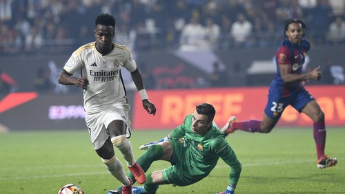 Real Madrids Vinicius Junior, left, passes through Barcelonas goalkeeper Inaki Pena during the Spanish Super Cup final soccer match between Real Madrid and Barcelona at Al-Awwal Park Stadium in Riyadh, Saudi Arabia, Sunday, Jan. 14, 2024. (AP Photo)