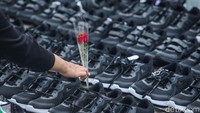 Dalam aksinya beberapa pengunjuk rasa turut meletakkan bunga di deretan sepatu.