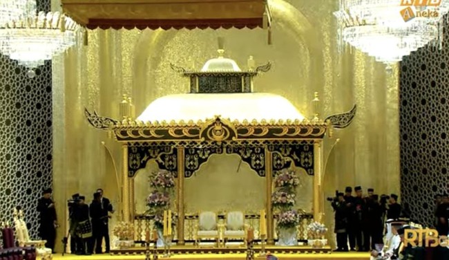 Pelaminan Pangeran Mateen dan Anisha dipayungi dengan kubah bermotif ukiran tradisional khas Brunei Darussalam. Pelaminannya itu tampak mewah dan elegan dengan warna putih, hitam, dan gold. Foto: YouTube/rtbnews