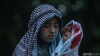 Mereka turut membawa boneka bayi yang turut berlumuran darah akibat pembantaian oleh Israel.