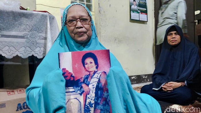 Anak Iyar Wiarsih menunjukkan foto almarhumah ibunya