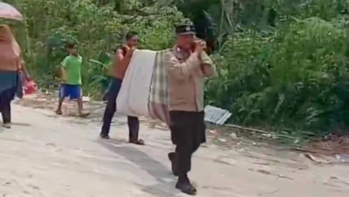 Bhabinkamtibmas di Inhil Riau viral di medsos karena ikut memanggul wanita yang baru melahirkan. Pak Bhabin itu bernama Bripa Heru. (Tangkapan layar video viral)