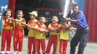 Siswa Taman Kanak-kanak (TK) menyemprotkan air bersama seorang petugas Pemadam Kebakaran dalam kegiatan Edukasi Penanggulangan Bencana Kebakaran di Markas Pemadam Kebakaran Kota Malang, Jawa Timur, Selasa (16/1/2024).