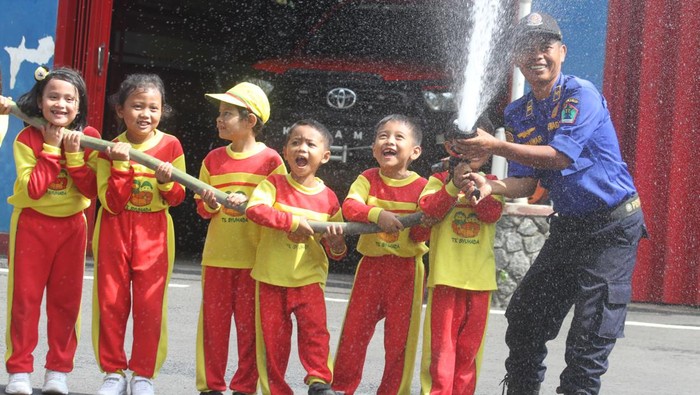 Seorang guru mempraktekkan cara menyelamatkan korban dalam kegiatan Edukasi Penanggulangan Bencana Kebakaran di Markas Pemadam Kebakaran Kota Malang, Jawa Timur, Selasa (16/1/2024). Kegiatan tersebut diadakan untuk memberikan edukasi mengenai langkah-langkah penanganan bencana kebakaran sekaligus pengenalan profesi Pemadam Kebakaran kepada sekitar 80 siswa Taman Kanak-kanak. ANTARA FOTO/Ari Bowo Sucipto/foc.