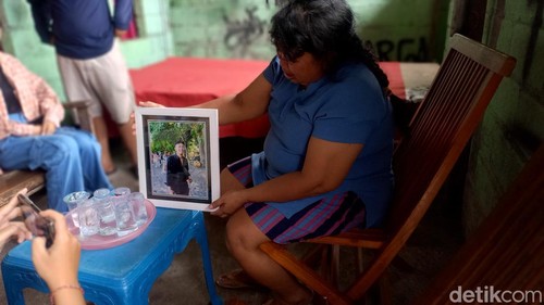 Ibu korban Putu Suartini (54) saat memperlihatkan foto almarhum Adhi Putra Krismawan kepada wartawan, Selasa (16/1/2023).