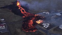 Foto-foto menunjukkan aliran lahar yang mengalir ke Grindavik, dengan bangunan-bangunan yang terbakar hanya berjarak beberapa meter dari rumah-rumah lainnya. Bjorn Steinbekk via AP.