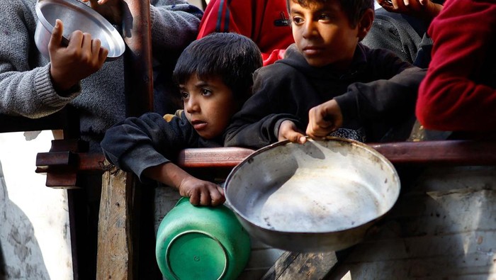 A child reacts as Palestinians wait to receive food cooked by a charity kitchen amid shortages of food supplies, amid the ongoing conflict between Israel and the Palestinian Islamist group Hamas, in Rafah in the southern Gaza Strip, January 16, 2024. REUTERS/Ibraheem Abu Mustafa